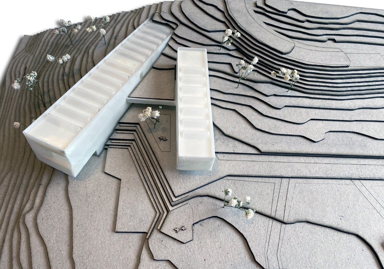 Maqueta arquitectónica de CONTEMPLATIO: volúmenes blancos sobre una topografía de curvas de nivel.